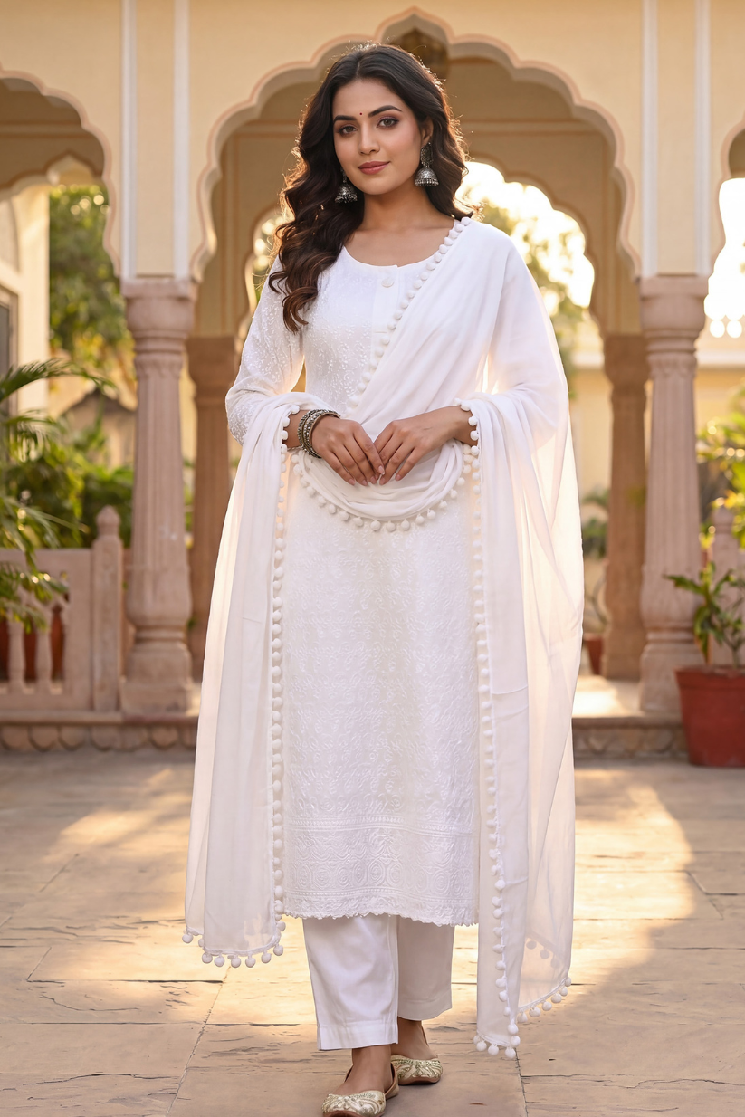 Woman in a white traditional outfit standing in front of an architectural background