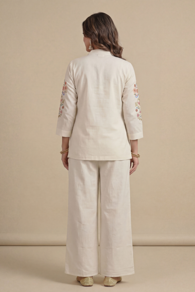 Back view of woman wearing ivory embroidered kurta set with jacket and palazzo pants