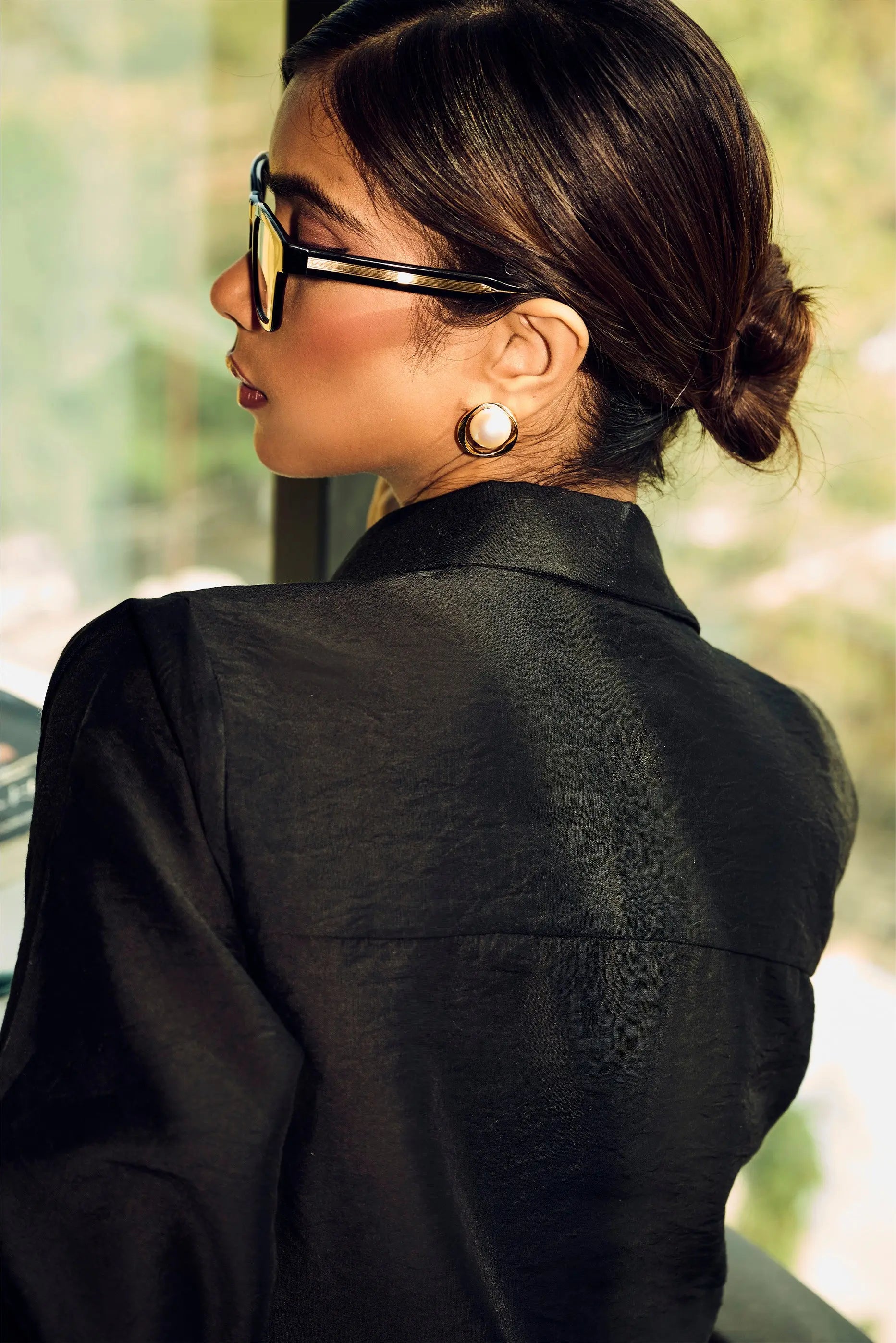 Back view of a woman wearing a black Chanderi regular fit shirt with elegant smart casual office styling