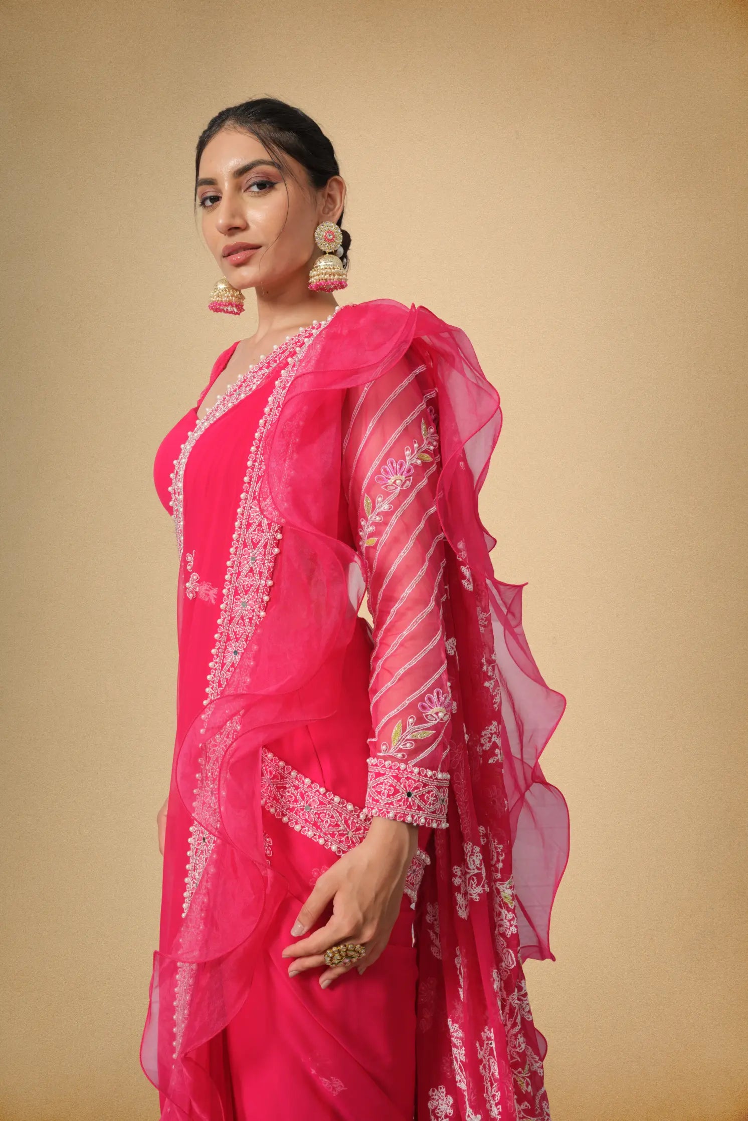 Closeup view of hot pink embroidered saree with organza ruffles