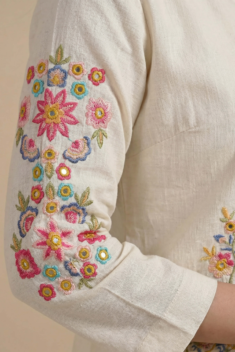 Close-up of floral embroidery detail on ivory ethnic jacket sleeve