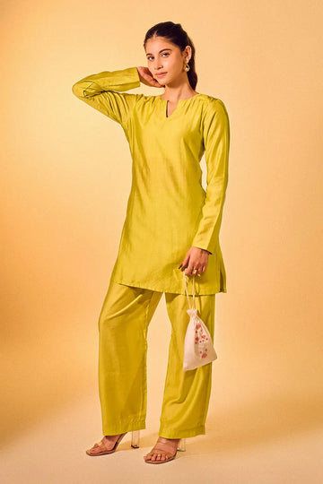 Woman wearing lime green Chanderi kurta set with straight pants and V-neck design