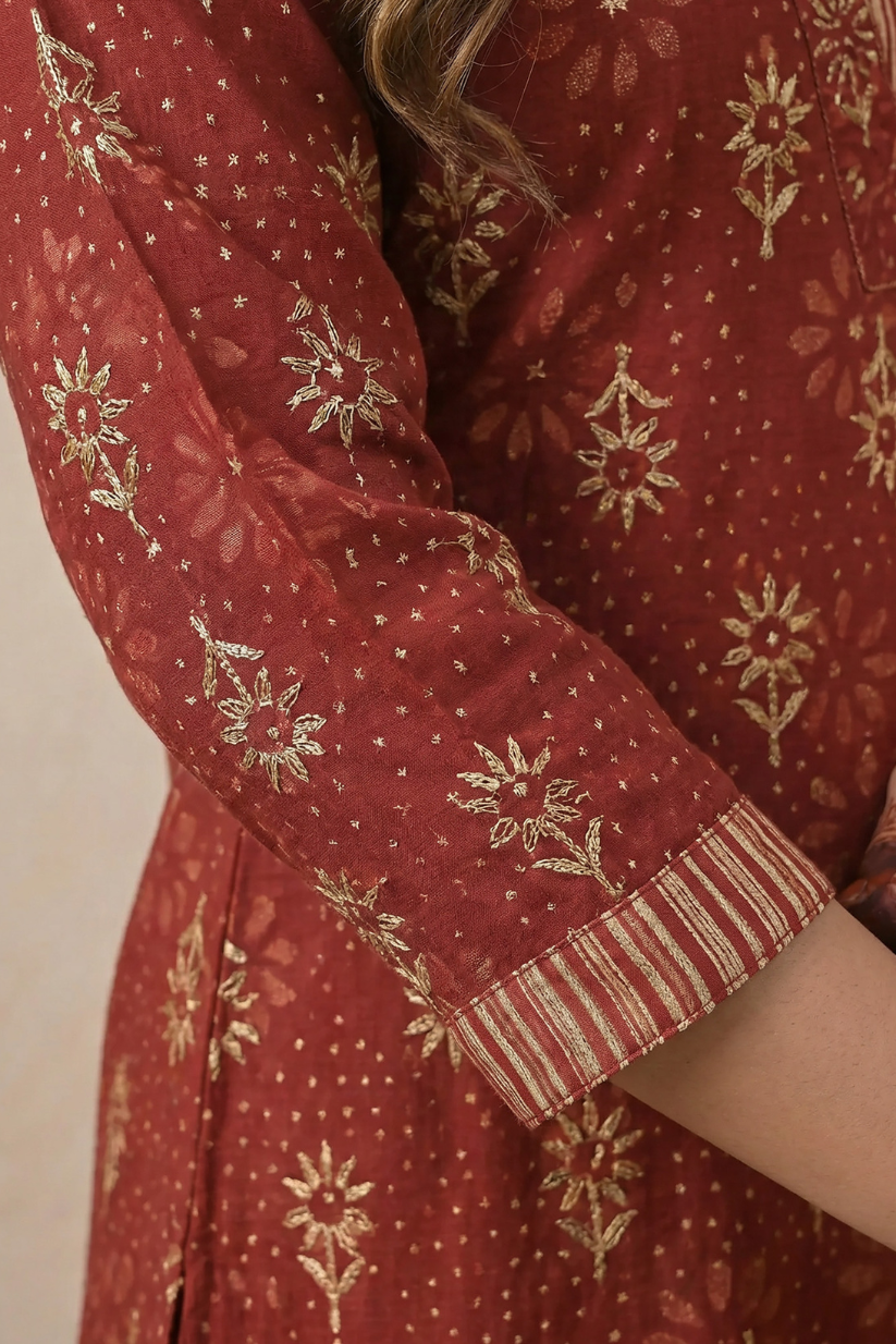 Close up of maroon printed kurta with golden motif embroidery and sleeve detailing for women