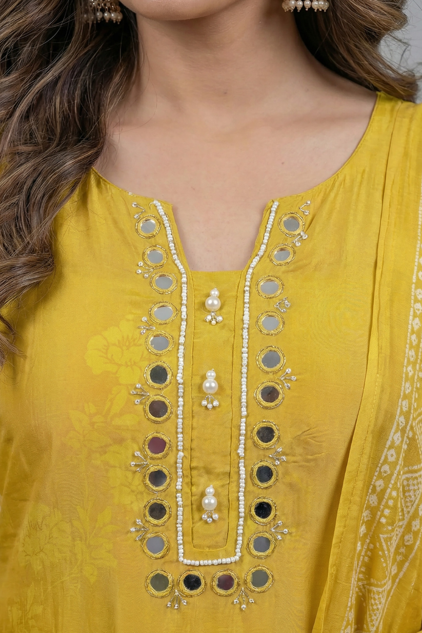 Woman wearing mustard yellow printed kurta set with mirror work dupatta front view