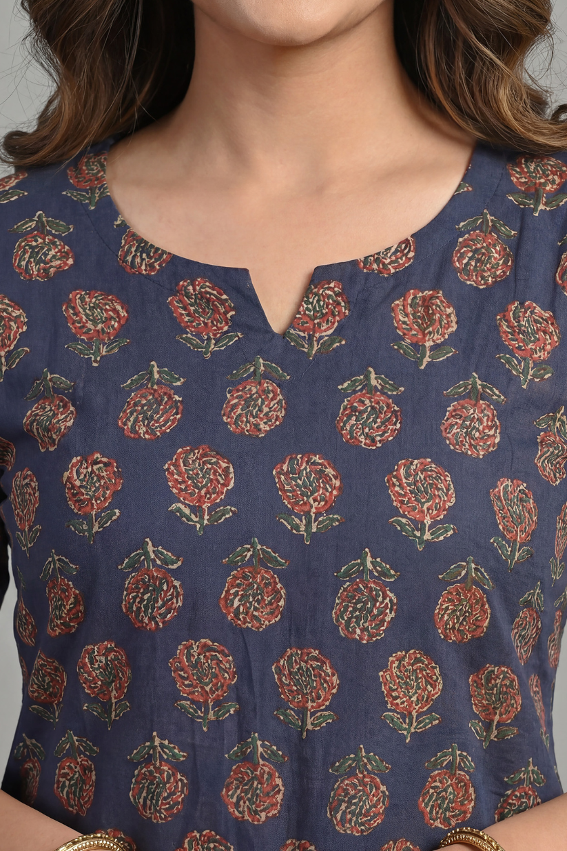 Woman wearing navy blue floral printed everyday kurta with blue jeans in outdoor garden setting