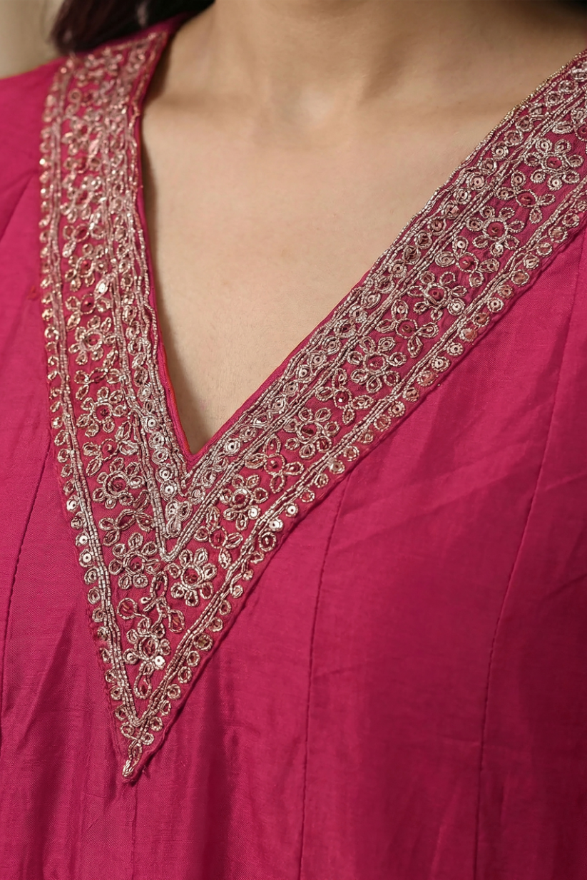 Woman wearing rani pink embroidered anarkali kurta set with scalloped dupatta