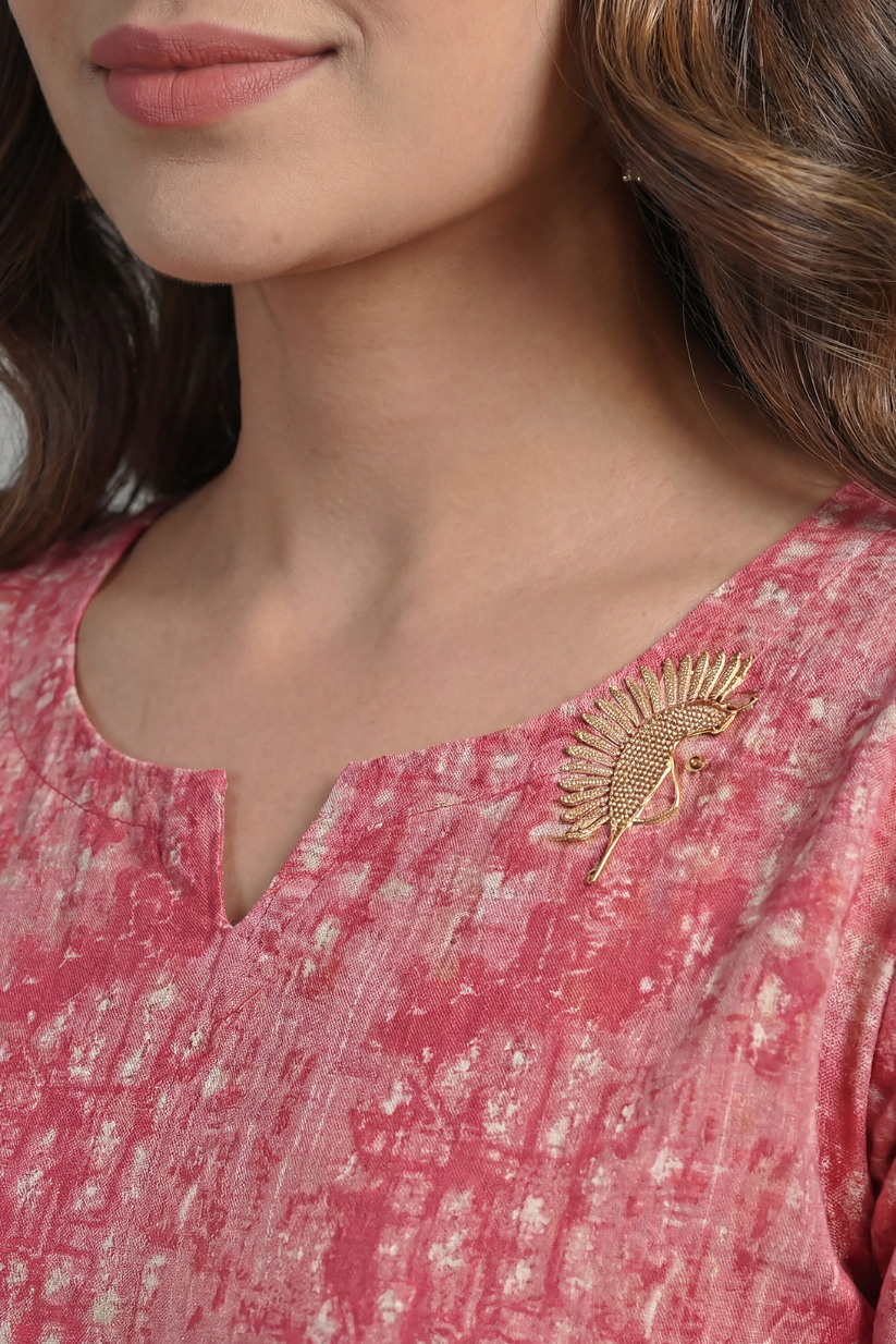 Woman wearing rose pink printed cotton kurta with blue jeans in outdoor garden setting