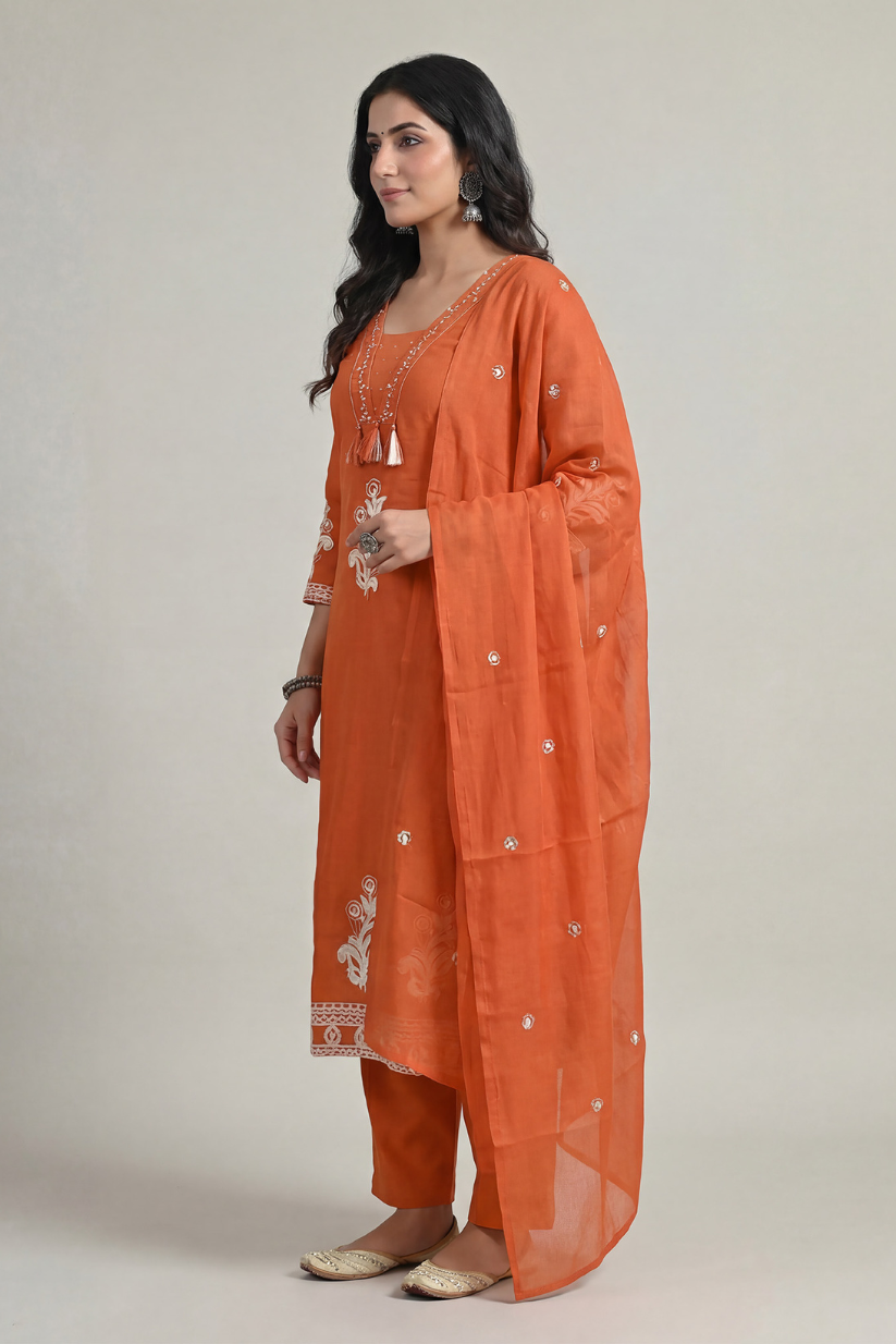 Side view of rust orange embroidered kurta set with dupatta and straight pants