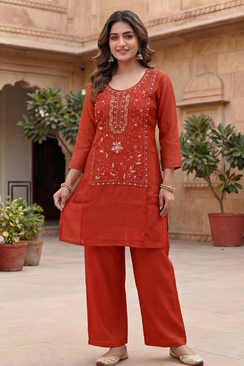 Woman wearing rust red embroidered kurta set with straight pants