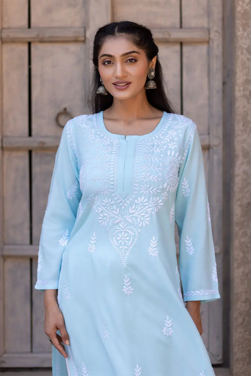 Closeup of white Chikankari embroidery on sky blue rayon kurti