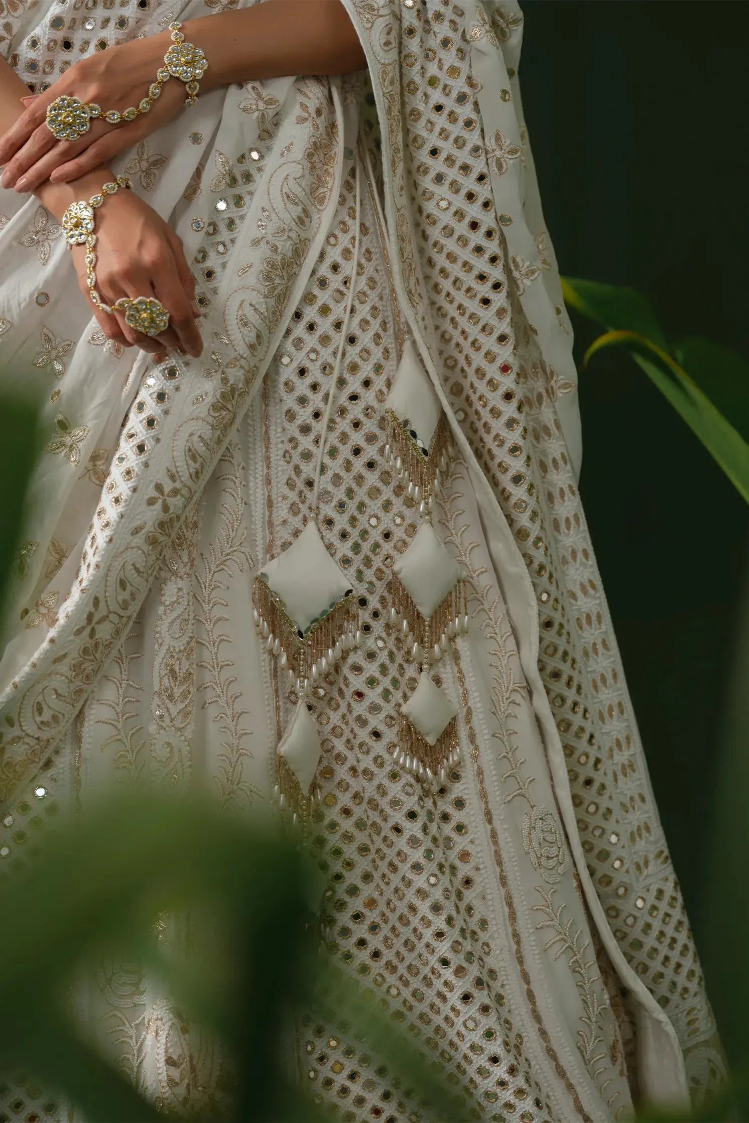 Closeup of mirror and zardozi work on white chikankari lehenga